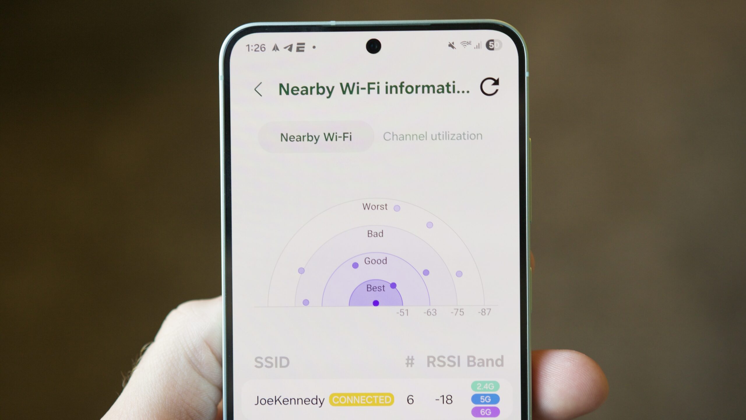 Mão segurando um smartphone Samsung exibindo interface da câmera com funções extras